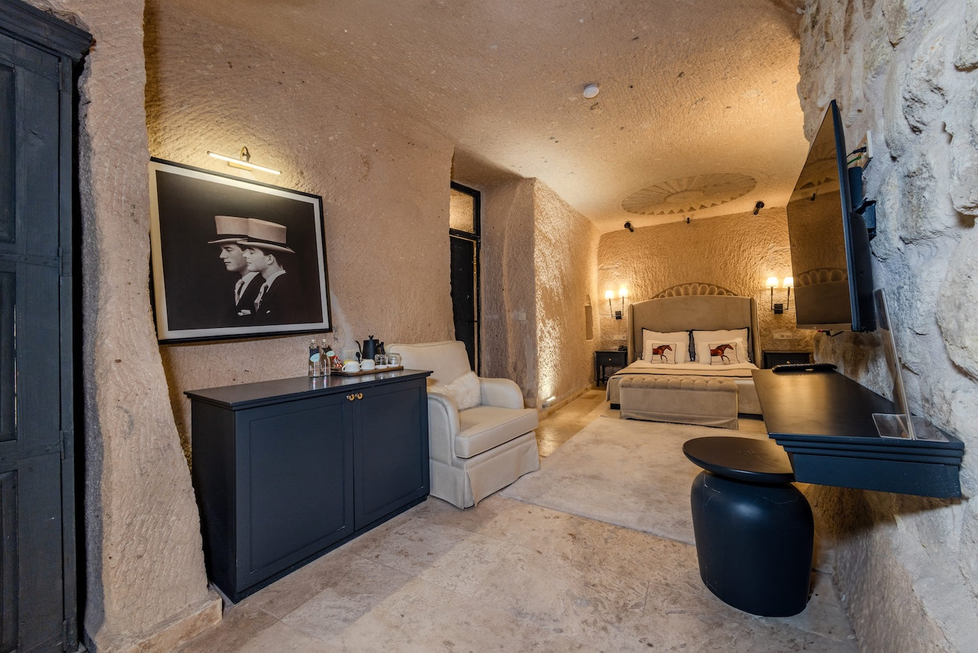 Luxury cave-style bedroom with stone walls, modern furniture, and decorative elements.