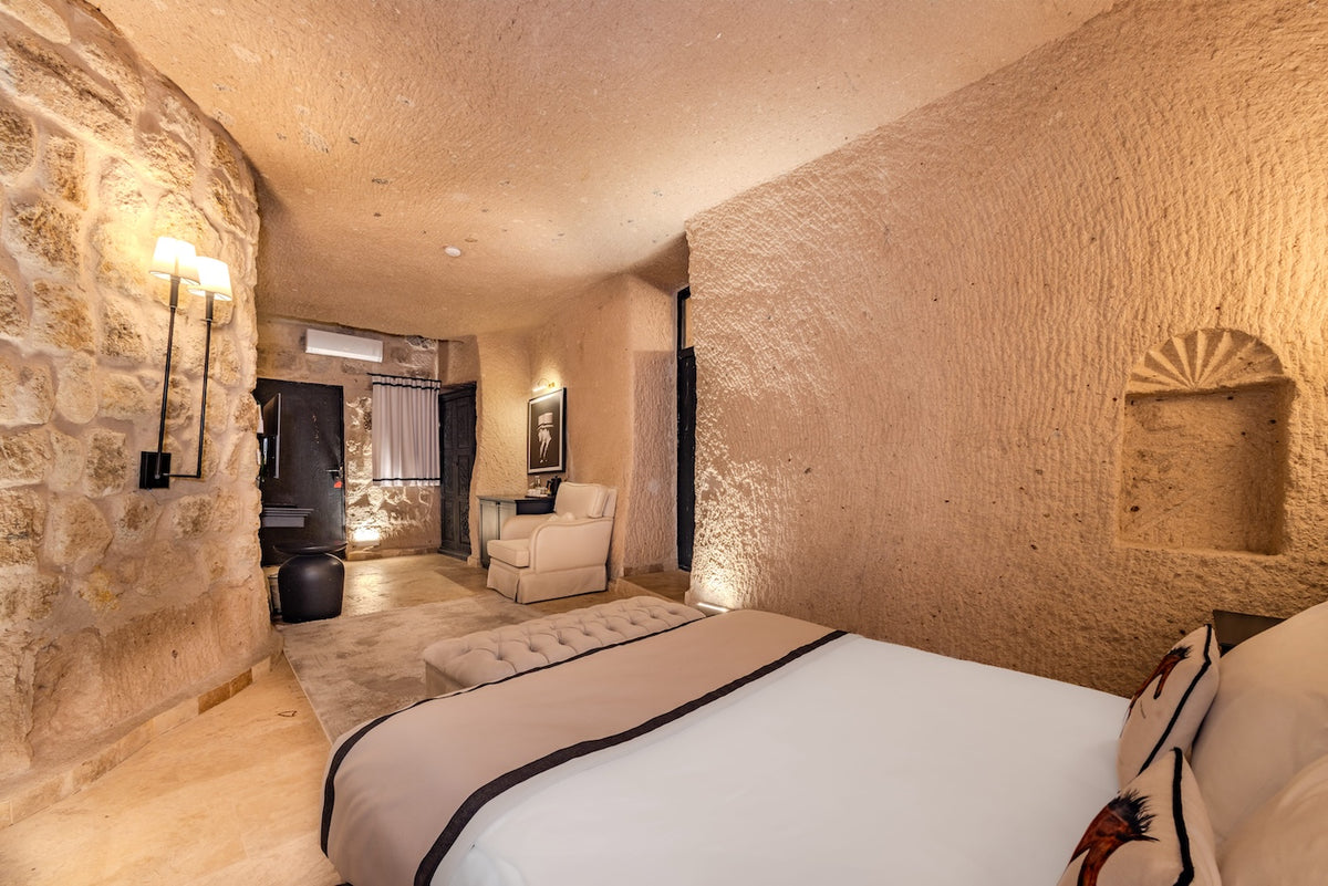 Bedroom with stone walls and modern decor in a cave-like setting